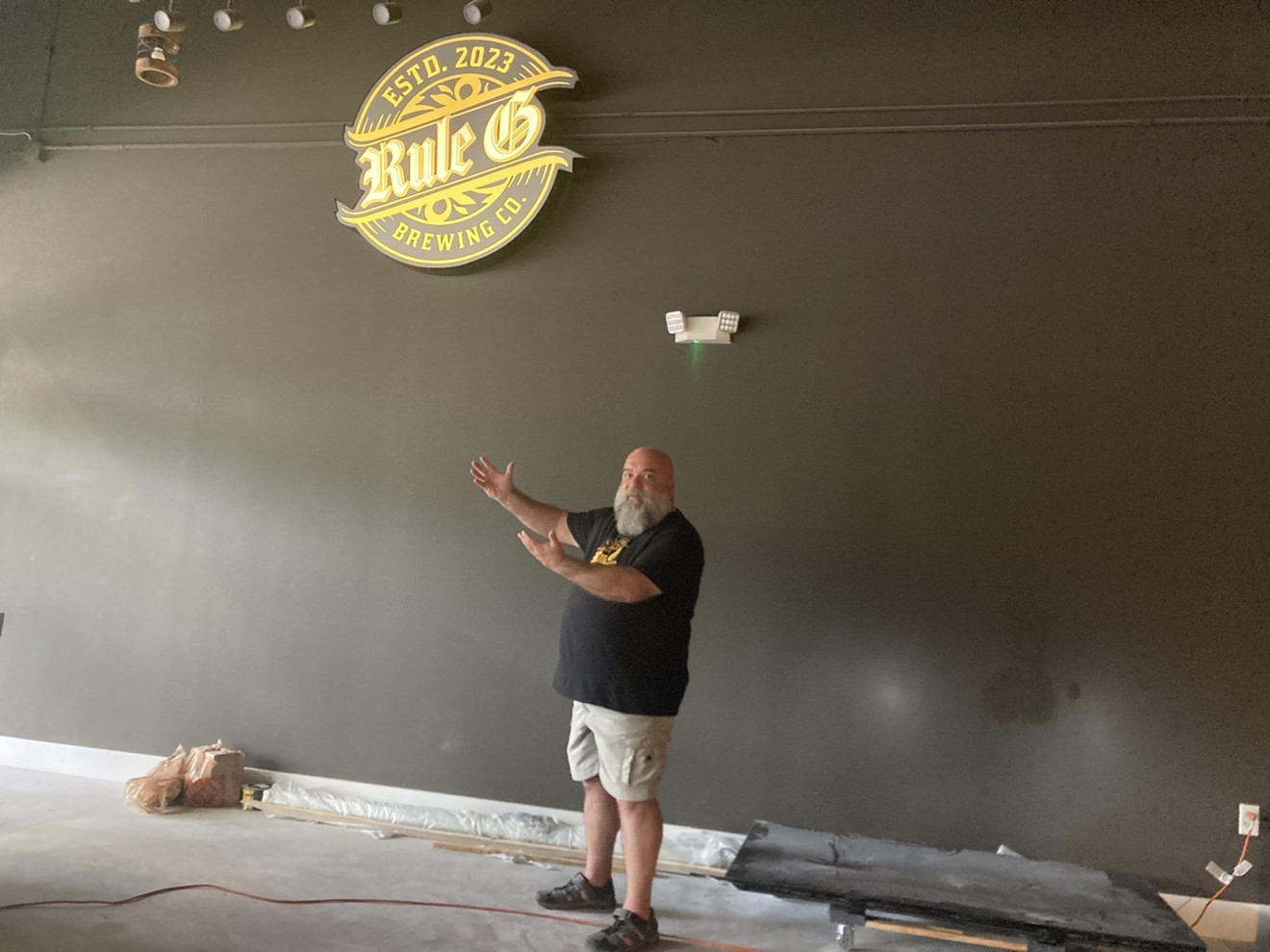 Rule G Brewing Company owner Ralph Rapa shows off an illuminated sign of his brewery during construction in October 2023.