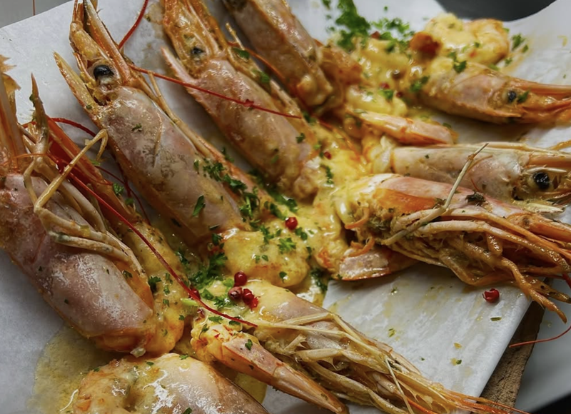 Image: Prawns in lemon sauce cooked on Sicilian terracotta tiles at Savia in Boca Raton