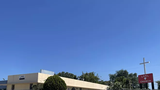 A tan building sits at the corner of SW 13th Street and SW 4th Avenue.