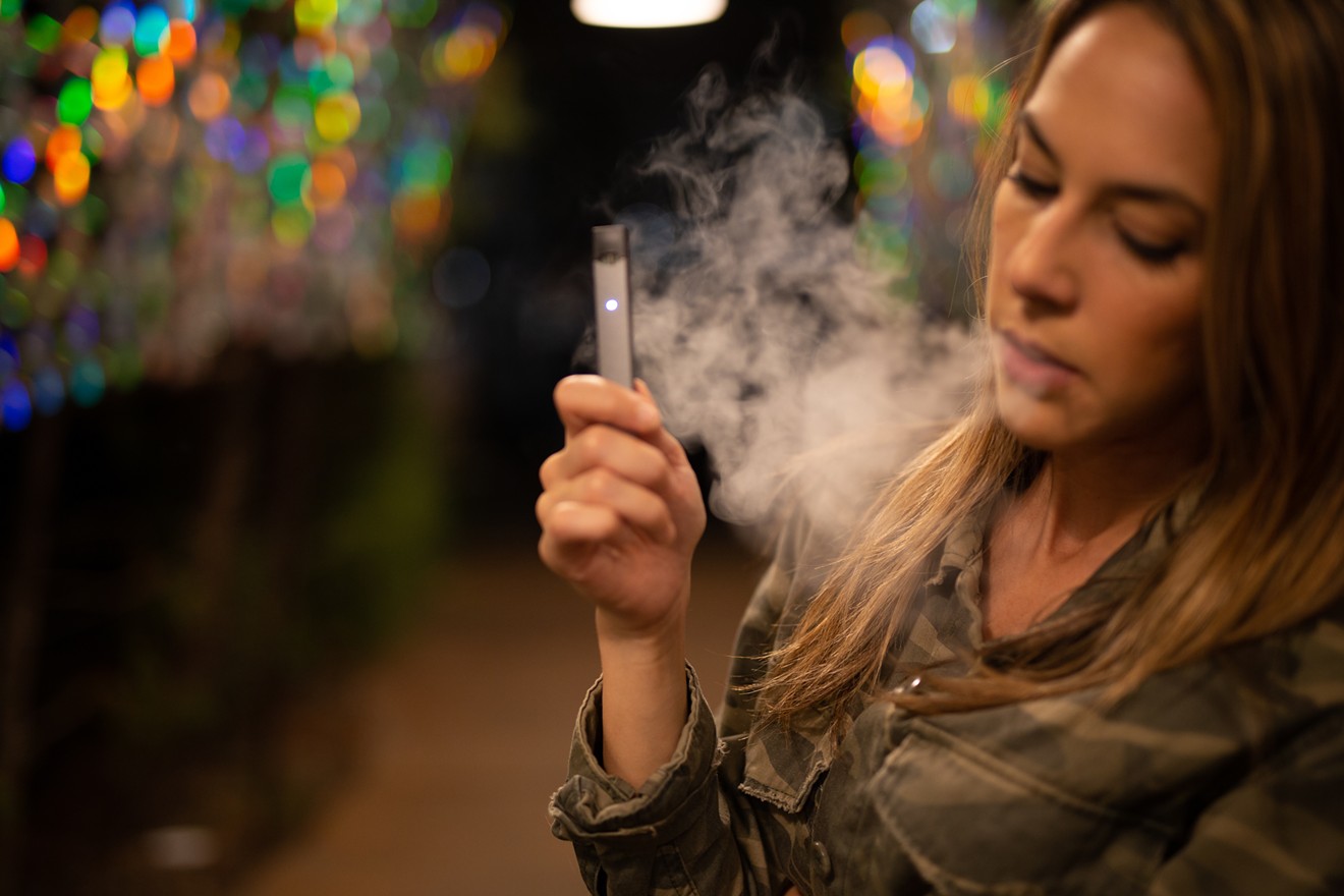 A young woman vaping, specifically "Juuling."
