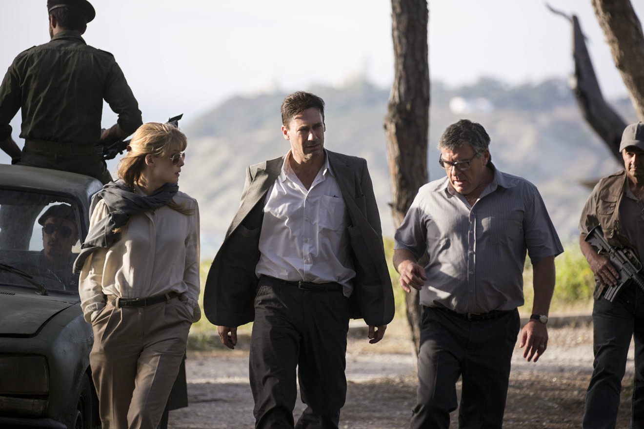 Jon Hamm (middle) plays Mason Skiles, a canny negotiator and  poker-faced talker who sees more angles than anyone else does in Brad Anderson’s thriller Beirut, which also stars Rosamund Pike (left).