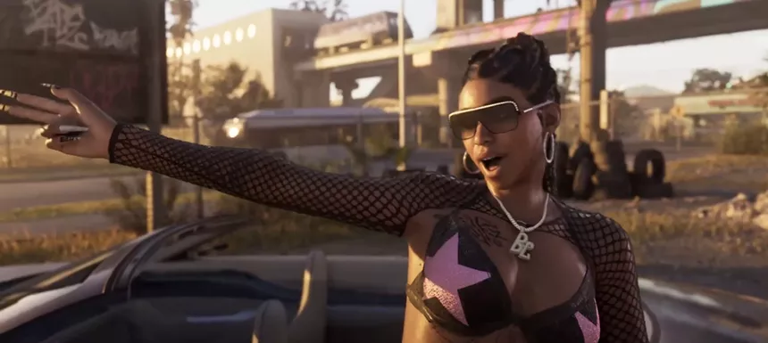 screenshot showing a woman wearing sunglasses, making a shooting motion with her fingers, with an elevated light rail car in the background