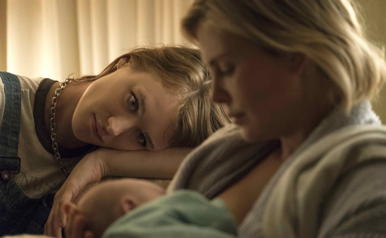 In Tully, Mackenzie Davis (left) plays the title character, a boho caregiver in high-waisted jeans and crop top who becomes a supportive female friend to Marlo (Charlize Theron), an overextended working mom.