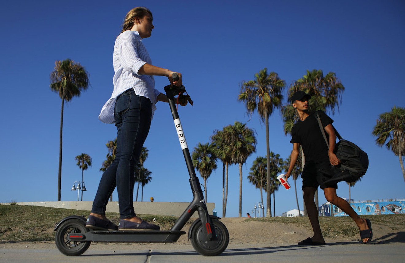 A woman drives an electric scooter on Venice Beach in Los Angeles.