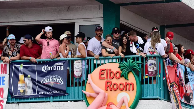 Florida Panthers fans stand alongside the second-story railing at Elbo Room in Fort Lauderdale during the 2024 parade